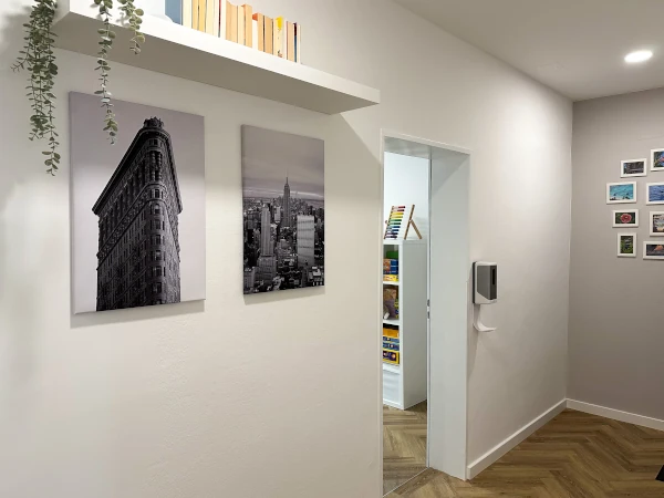 Hallway with pictures of buildings in New York and a view of therapy room 1